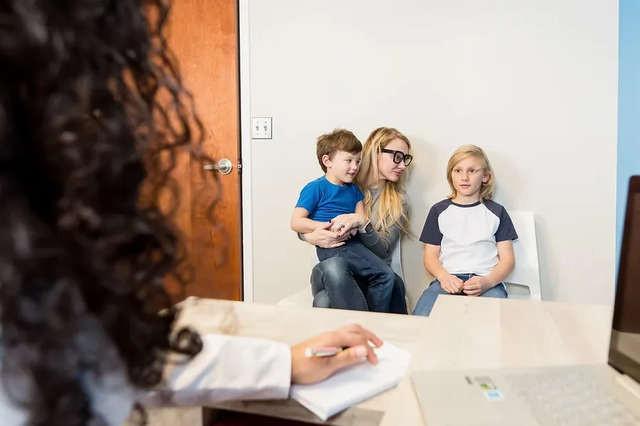 Dr Uma, double board-certified pediatrician and IBCLC, with a mother and her two children at the Huntersville NC office