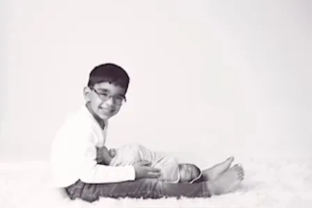 Proud big brother sitting beside his sleeping newborn sibling